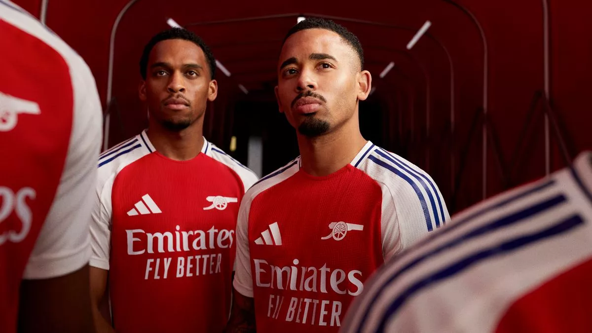 The 2024–25 Arsenal home uniform has been unveiled; here's how to acquire the new adidas shirt and strip, which features a significant badge redesign. The home uniform for Arsenal's 2024–25 campaign has been unveiled. The Emirates' renowned cannon is embroidered onto the chest of the shirt of the Gunners' new uniform, replacing the customary club emblem for the first time in thirty-five years. In addition to its traditional red and white composition, the uniform features navy stripes running along the body and neckline. Gabriel Martinelli was questioned regarding the design and appearance of the new badge. He responded, "Since joining Arsenal, it has become abundantly obvious to me how vital the cannon is to this great club and its supporters. "It proudly represents our organization, and we cannot wait to don it on the field the following season." Alessia Russo, forward for the Women's Team, commented, "I adore the straightforwardness of this new uniform, which allows the cannon to stand out. We understand its significance to the supporters; therefore, featuring it prominently on our home uniform will instill a sense of assurance in us each time we enter the playing field. As is customary, Arsenal could don the new uniform on Sunday afternoon at the Emirates Stadium when they host Everton in their concluding match of the season. The Gunners could earn their first Premier League championship since 2004 on that particular afternoon if they can secure a favor from West Ham United in their match against Manchester City. A victory would require them to collect three points against Everton, which would be enough to edge Pep Guardiola's squad to the championship 